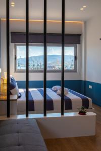 two beds in a room with two windows at Central Marine Flat in Volos