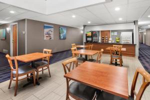 サンブルーノにあるHotel Aura SFO Airport FREE SHUTTLEのダイニングルーム(木製のテーブルと椅子付)