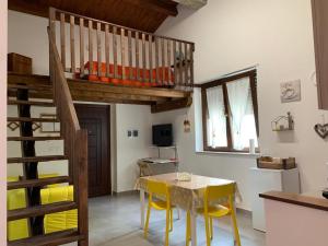 a kitchen with a table and yellow chairs in a room at Campagna D'aMare in Atessa