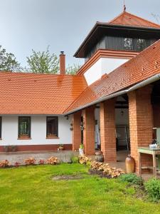 a brick house with an orange roof at Guest House Vidravar in Tabdi