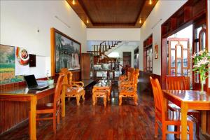 uma sala de jantar com mesas e cadeiras de madeira em Thao Nguyen Phat Homestay em Hoi An