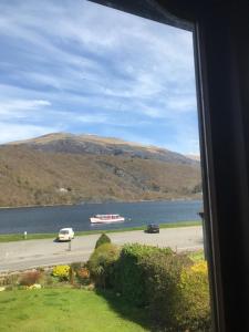 a view of a boat on the water from a window at Gwêl y Dŵr in Llanberis