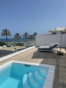 a swimming pool on the roof of a house with an umbrella at Pasitoblanco Porto Mare 45 Seaview Villa prívate heated pool in Pasito Blanco