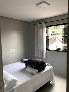 uma cama num quarto com uma grande janela em Hotel Pousada Bueno's em Francisco Beltrão
