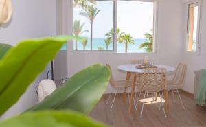 a dining room with a table and chairs and the ocean at Apartamento En calma in Peniscola