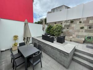 un patio con tavolo, sedie e parete di Casa da Miragaia ad Angra do Heroísmo