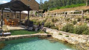 a swimming pool in a yard with a stone wall at A Casa das Augas in Mondoñedo