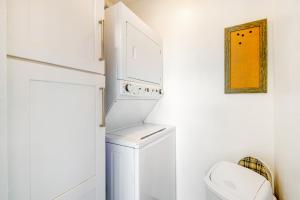 a white laundry room with a washer and dryer at Captain's Quarter in Johnson Landing