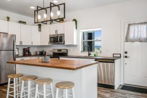 a kitchen with white cabinets and a counter with stools at The Villas 12A in Pagosa Springs