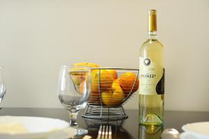 a bottle of wine sitting next to a basket of oranges at Prestige Apartments in Zadar