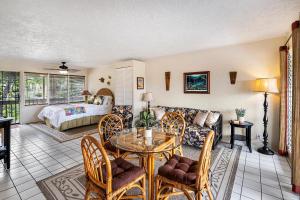 a living room with a table and a couch at Kona Shores #203 in Kailua-Kona +18 photos