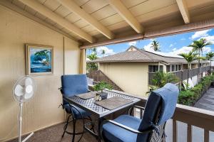 a patio with a table and chairs on a balcony at Kona Shores #203 in Kailua-Kona