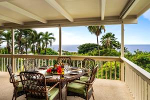a table on a balcony with a view of the ocean at Kona Sunset House at Walua in Kailua-Kona