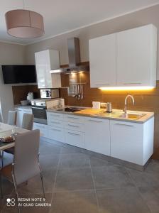 uma cozinha com armários brancos e uma mesa com cadeiras em La Carrozza sul Titerno em Faicchio