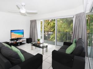 uma sala de estar com um sofá e uma televisão de ecrã plano em Mainsail 3 em Mooloolaba