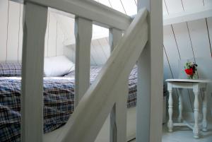a bedroom with a bed and a staircase with a table at Bed In Waterland in Broek in Waterland