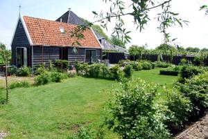 a garden in front of a house at Bed In Waterland in Broek in Waterland
