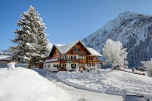 a log cabin in the snow with a christmas tree at Bödmerhof in Mittelberg