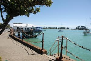 ein Dock mit einem Gebäude auf dem Wasser mit Booten in der Unterkunft Century Park in Nelson