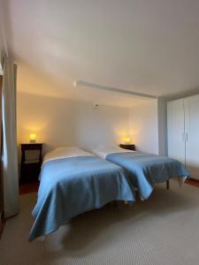 a bedroom with two beds with blue comforters at Casa do Sétimo Passo in Marvão