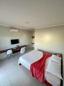 um quarto de hotel com uma cama e uma televisão em Bella Spiaggia Suítes em Flecheiras