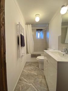 a white bathroom with a toilet and a sink at Casa do Sétimo Passo in Marvão +31 photos