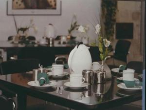 a table with dishes and a tea set on it at Hotel Ambiente in Hof