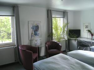 Hotel Ambiente في هوف: غرفة فندقية بسريرين وطاولة وكراسي