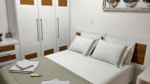 1 dormitorio pequeño con armarios blancos y 1 cama en Paz & Diversão Praia Do Forte, en Praia do Forte 47 fotos más