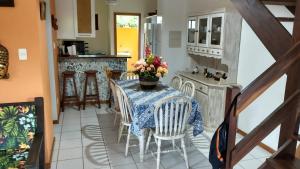 a kitchen with a table and chairs with flowers on it at Paz & Diversão Praia Do Forte in Praia do Forte