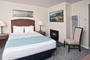 a hotel room with a bed and a fireplace at Villa Franca Inn in Monterey