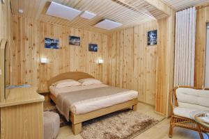 a bedroom with a bed in a room with wooden walls at Tourist complex Gornoe Ozero in Artybash