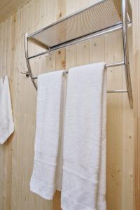 two white towels hanging on a towel rack in a bathroom at Tourist complex Gornoe Ozero in Artybash