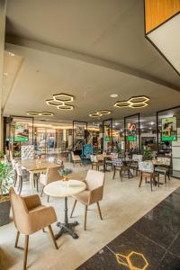 Solano Hotel في ليبا: مطعم بطاولات وكراسي ونوافذ