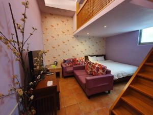 a small room with a bed and a couch and a bed and a staircase at 17 Happiness in Xiaoliuqiu