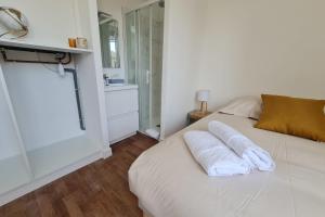 sypialnia z białym łóżkiem i ręcznikami w obiekcie Le Poulorio 7 - T2 - Proche Gare By Locly w mieście Lorient
