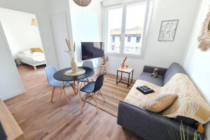 ein Wohnzimmer mit einem Sofa und einem Tisch in der Unterkunft Le Poulorio 7 - T2 - Proche Gare By Locly in Lorient