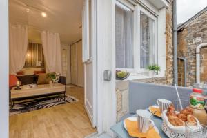 una sala de estar con una mesa con comida. en L'Alexandrin, en Charleville-Mézières