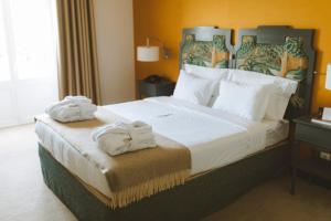 une chambre d'hôtel avec un grand lit et des serviettes. dans l'établissement Conimbriga Hotel do Paço, à Condeixa-a-Nova