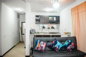 ein Wohnzimmer mit einem Sofa und einer Küche in der Unterkunft Apartasol santa fe de Antioquia in Santa Fe de Antioquia