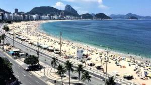 uma praia com muita gente e o oceano em Hotel Vitória no Rio de Janeiro