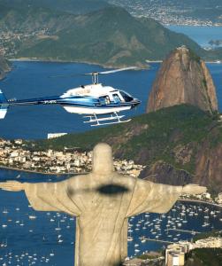 リオデジャネイロにあるホテル ヴィトーリアの贖い手の聖像上空を飛ぶヘリコプター