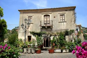 an old building with flowers in front of it at B&B Il Padrino in Savoca