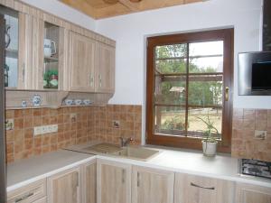 une cuisine avec un évier et une fenêtre dans l'établissement Dom WIESIA Kaszuby do 8 os., à Olpuch