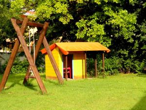 a yellow and orange dog house in the grass at Agriturismo Colomboni in San Costanzo