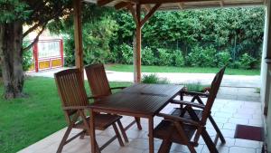 a wooden table and chairs on a patio at Tiszafa Apartman in Csopak