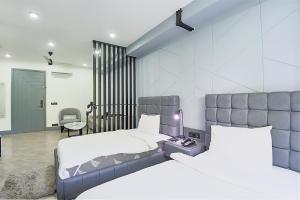 a bedroom with two beds and a desk and a chair at BedChambers Serviced Apartments - Cyber City in Gurgaon