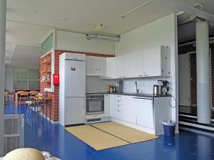 a kitchen with white cabinets and a blue floor at Vanha koulu in Suolahti