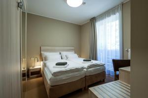 a bedroom with a large bed and a window at Horský hotel Lorkova vila in Čeladná