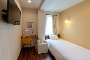 a hotel room with a bed and a desk and a television at ELE Hotel 東上野 in Tokyo